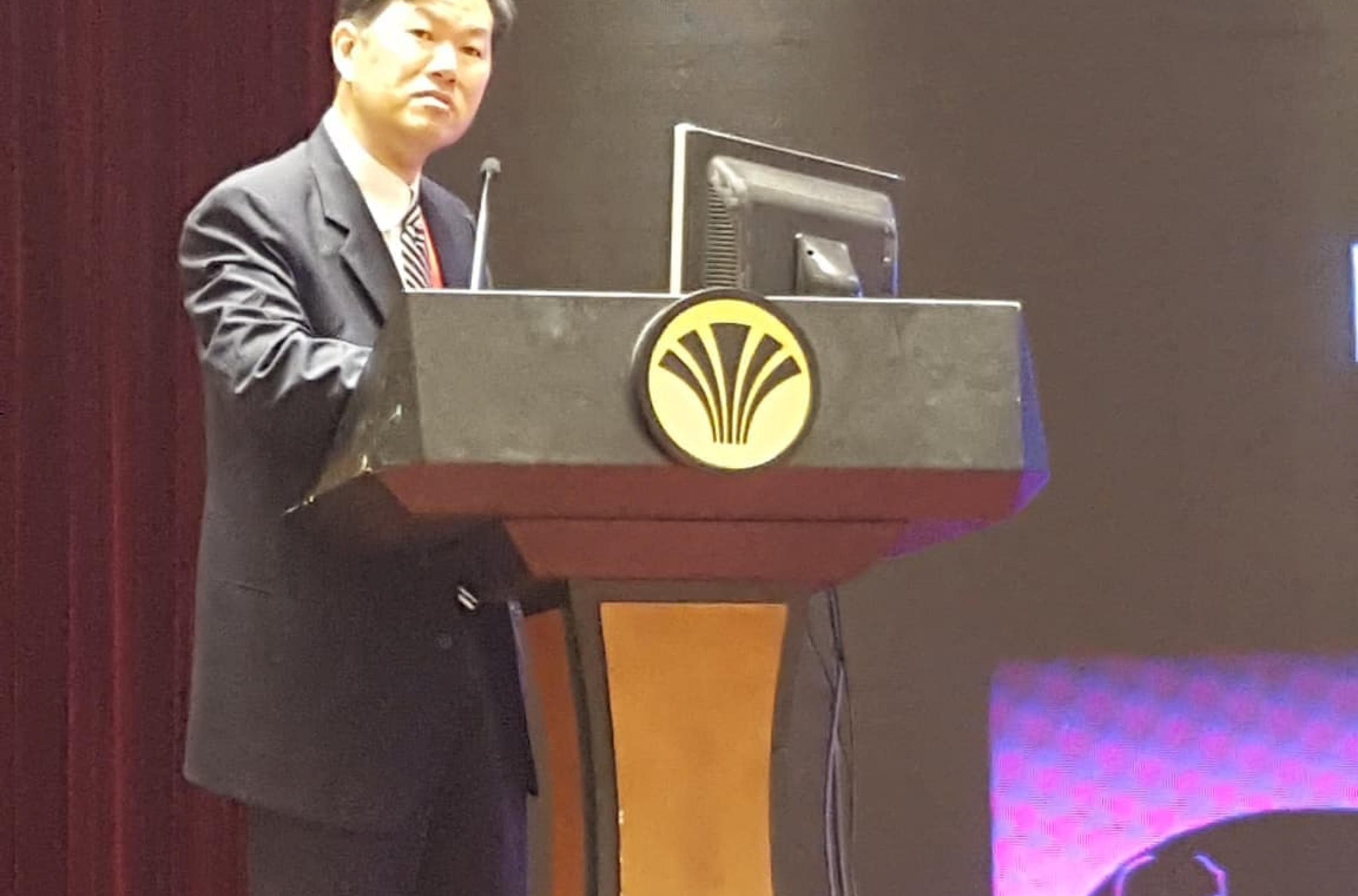 Dr. Kung speaking at a podium