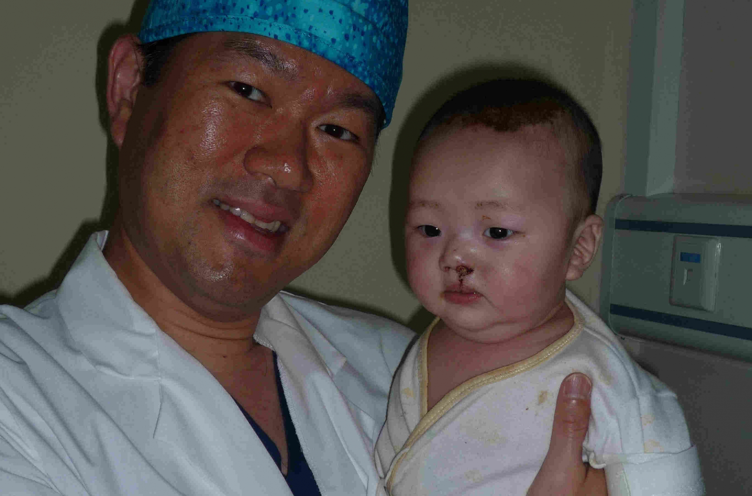 Dr. Kung holding a child after surgery.